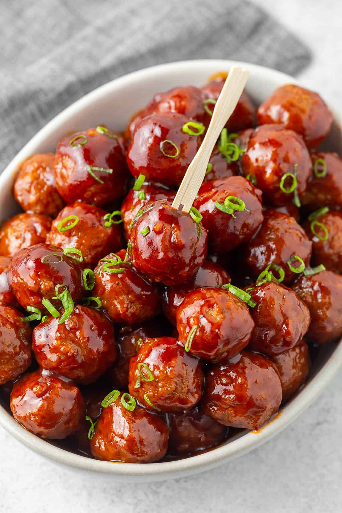 Slow Cooker Bourbon BBQ Meatballs in a large bowl with a wooden toothpick. 