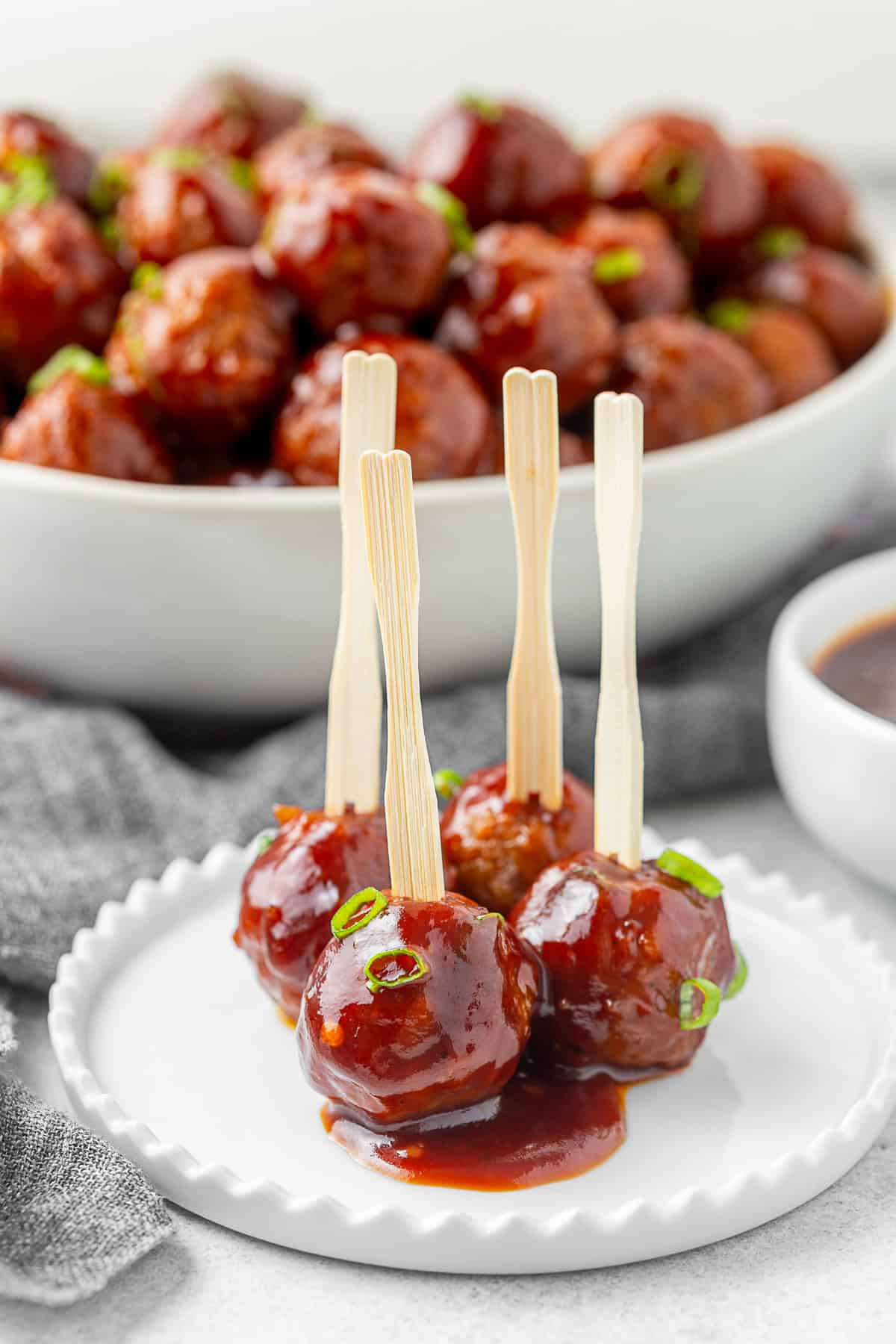 Four bbq meatballs on a plate. 