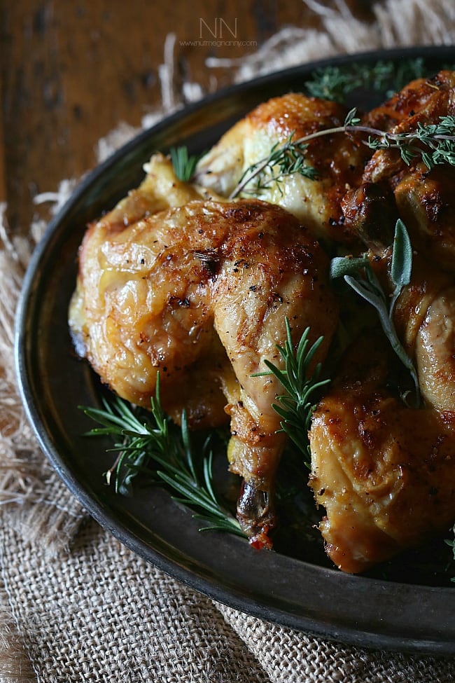 This lemon herb spatchcock Cornish hen is the perfect way to evenly cook Cornish hens. Simply cut, lay flat and rub with lemon herb butter. Hello dinner! Lemon Herb Spatchcock Cornish Hen cut up on a serving platter.