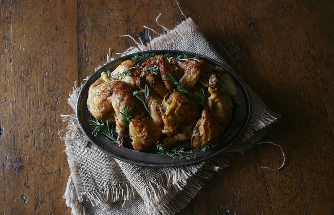 This lemon herb spatchcock Cornish hen is the perfect way to evenly cook Cornish hens. Simply cut, lay flat and rub with lemon herb butter. Hello dinner! Lemon Herb Spatchcock Cornish Hen cut up on a tray.