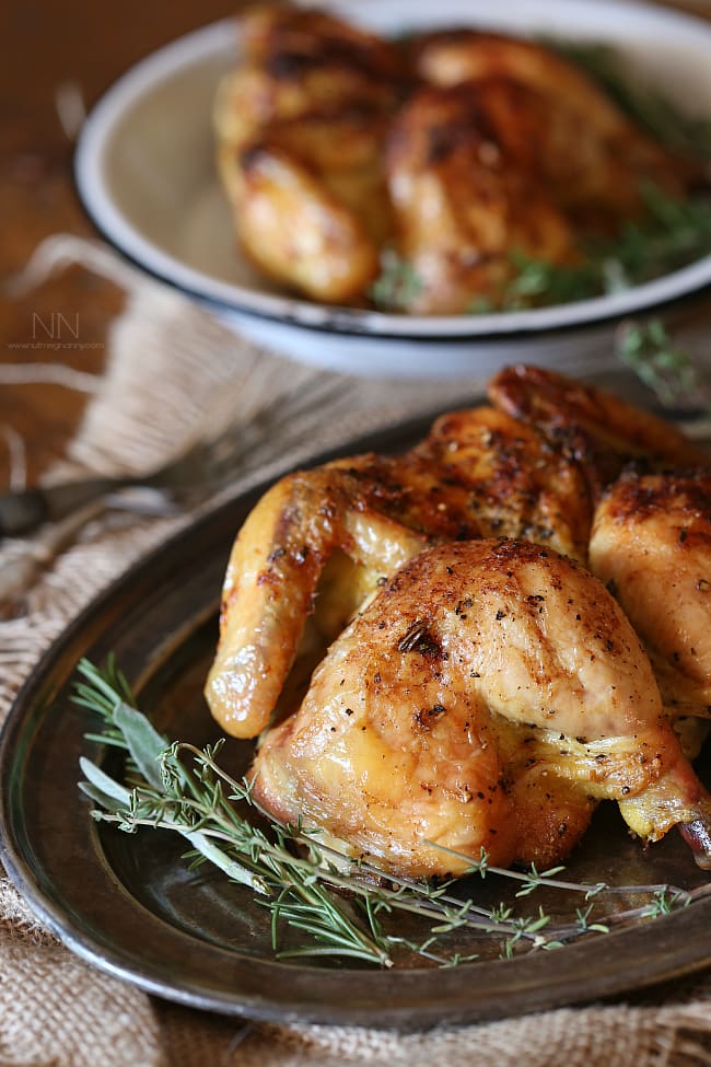 This lemon herb spatchcock Cornish hen is the perfect way to evenly cook Cornish hens. Simply cut, lay flat and rub with lemon herb butter. Hello dinner! Lemon Herb Spatchcock Cornish Hen served on a platter with fresh herbs.