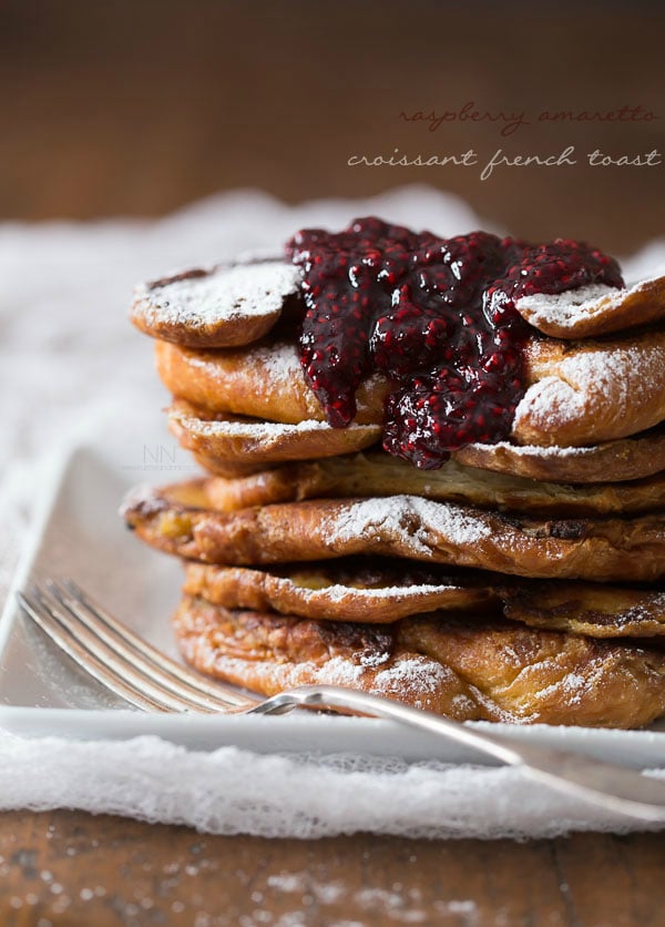 stacked croissant french toast topped with raspberry sauce. 