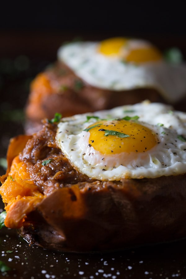 BBQ Pulled Pork Stuffed Sweet Potatoes topped with a fried egg and cilantro.