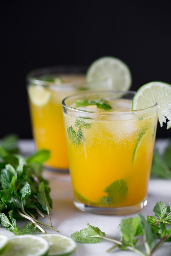 mango mojito in a short cocktail glass garnished with fresh lime and mint