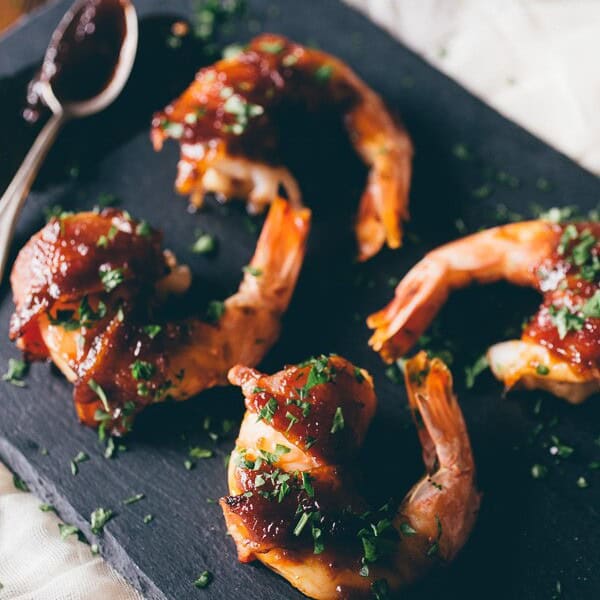 apple butter bacon wrapped shrimp on a black appetizer board