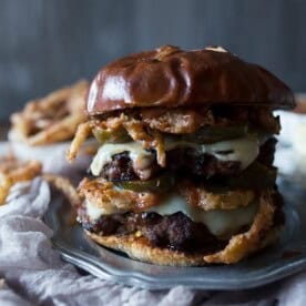 This chorizo beef burger with crispy onion straws is the perfect big mouth burger. Topped with bbq fry sauce, candied jalapeños and American cheese.