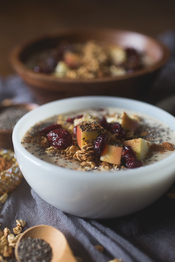 Apple Pie Smoothie Bowl topped with apples, chia seeds, and dried cranberries.