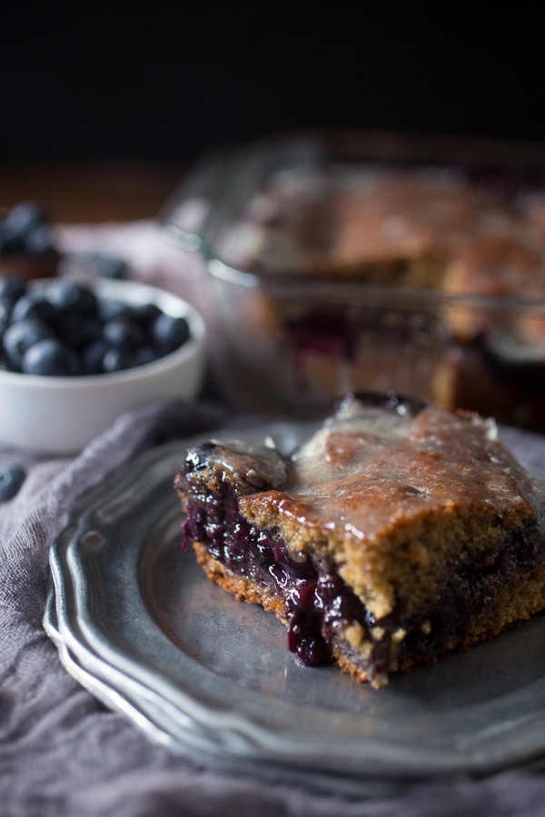 This blueberry fritter cake is the perfect way to celebrate the bounty of summer - sweet cinnamon scented cake with a warm blueberry center topped with vanilla bean glaze. It's like you favorite bakery fritter but in easy to make cake form. Trust me, you'll love the taste of the cake and it's perfect for breakfast or dessert.