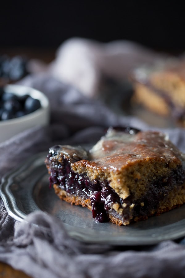 This blueberry fritter cake is the perfect way to celebrate the bounty of summer - sweet cinnamon scented cake with a warm blueberry center topped with vanilla bean glaze. It's like you favorite bakery fritter but in easy to make cake form. Trust me, you'll love the taste of the cake and it's perfect for breakfast or dessert.