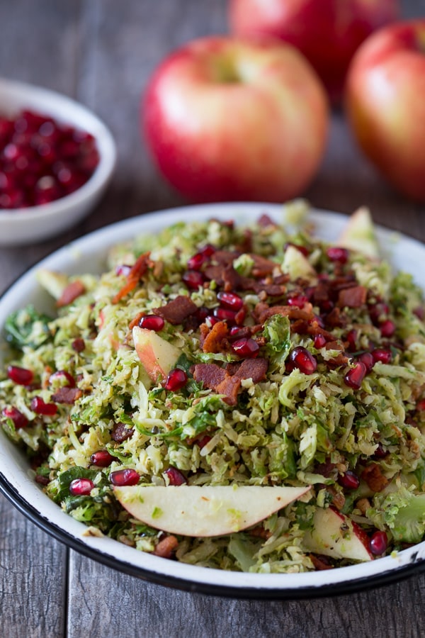 Shaved Brussels Sprout Apple Bacon Salad served with pomegranate seeds. 