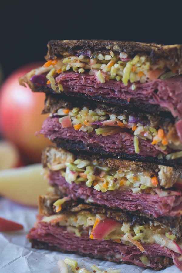 This tangy apple slaw corned beef reuben is the perfect fall sandwich. Perfectly toasted marble rye topped with an apple cabbage slaw, corned beef, melted swiss cheese and lots of homemade Russian dressing.