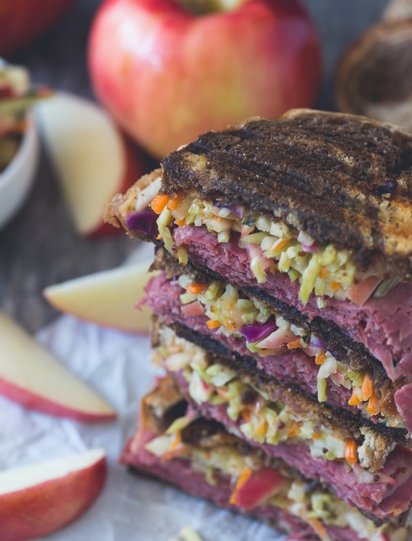 This tangy apple slaw corned beef reuben is the perfect fall sandwich. Perfectly toasted marble rye topped with an apple cabbage slaw, corned beef, melted swiss cheese and lots of homemade Russian dressing.