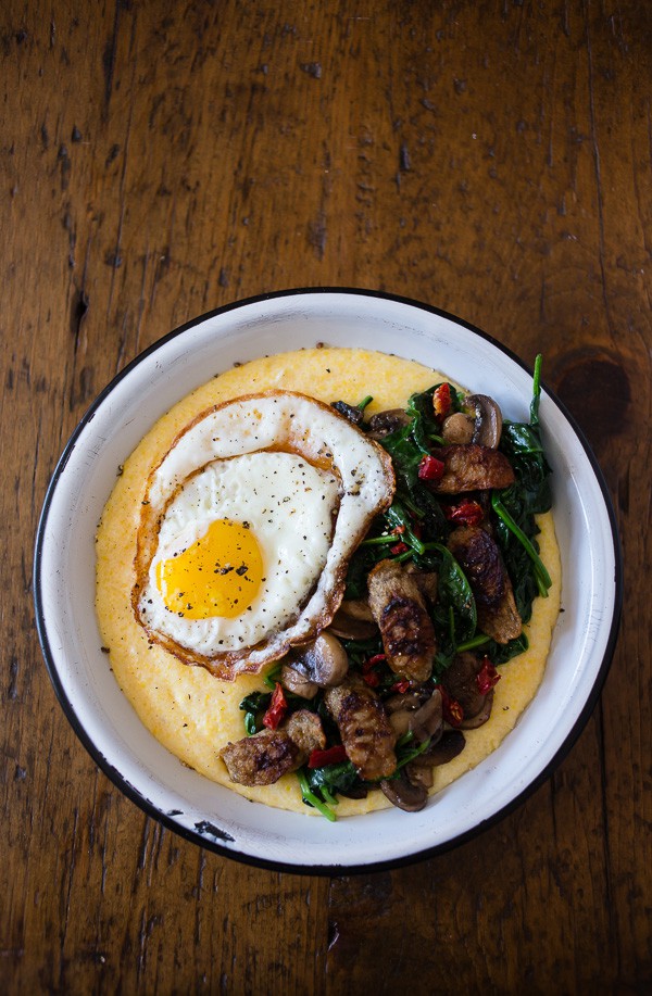 This cheesy polenta sausage breakfast bowl is packed with flavor. It starts with cheesy polenta topped with spinach, mushrooms, sun dried tomatoes, chicken sausage and topped with a crispy fried egg. Never skip breakfast again!