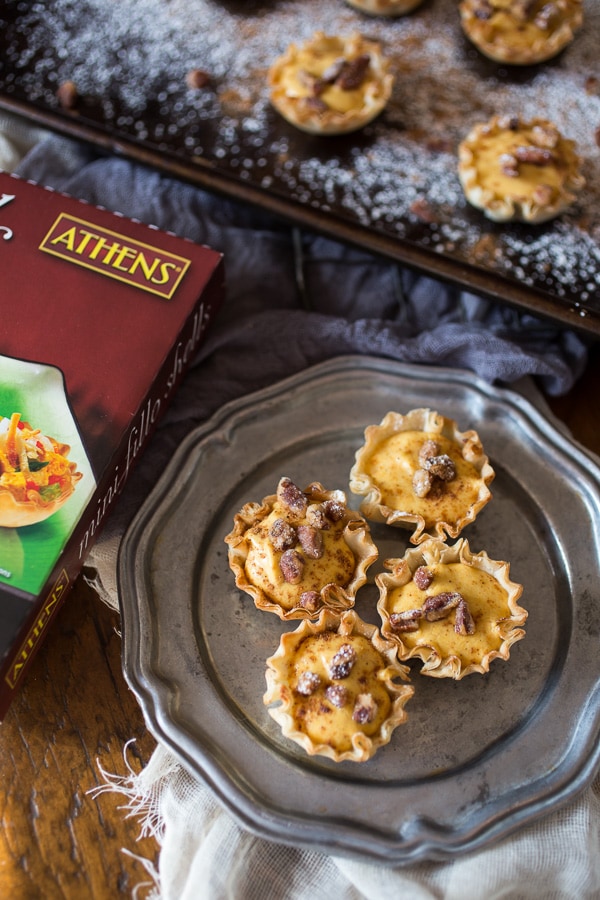 These no bake pumpkin cheesecake phyllo bites are the easiest Thanksgiving dessert ever. Fluffy spiced pumpkin cheesecake filled into crunchy phyllo shells and topped with spiced nuts. You'll love these sweet little bites!