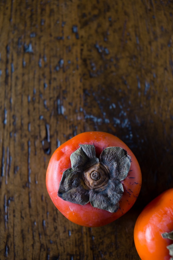 Persimmons sitting on a table. 