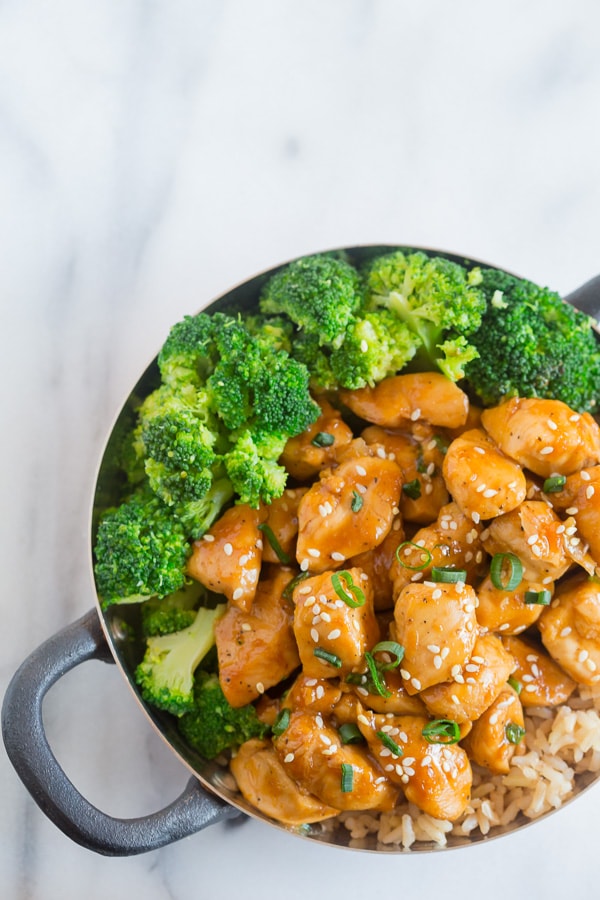 This 20 minute healthier orange chicken is the perfect weeknight dish. Healthier Orange Chicken in a bowl with sesame seeds.
