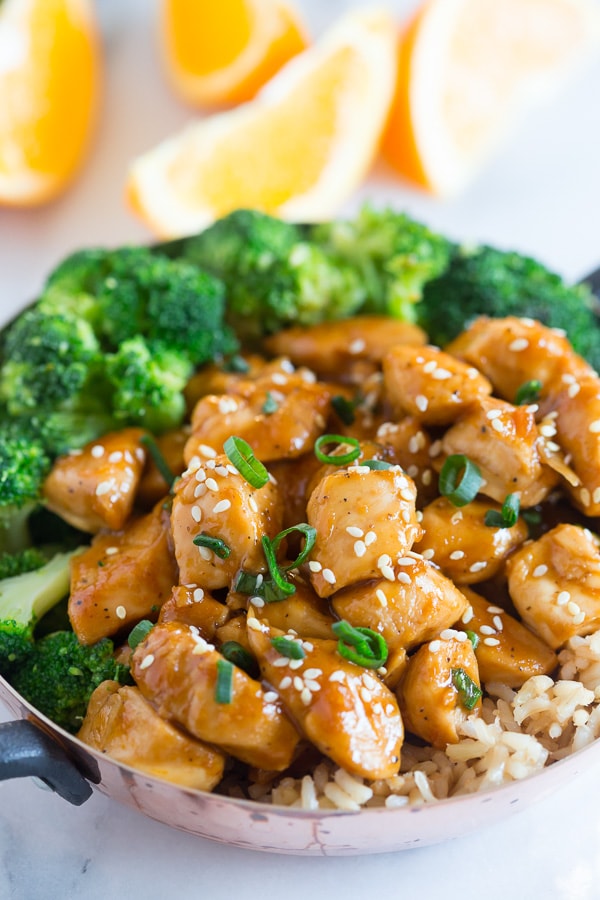 This 20 minute healthier orange chicken is the perfect weeknight dish. Why pay for take out when you can make this quick and easy dish from scratch. Trust me, you'll LOVE this dish it's seriously that EASY! Healthier Orange Chicken served with broccoli.