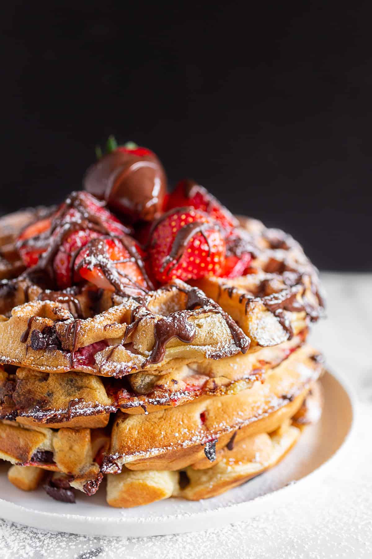 chocolate covered strawberry waffles topped with drizzled chocolate.