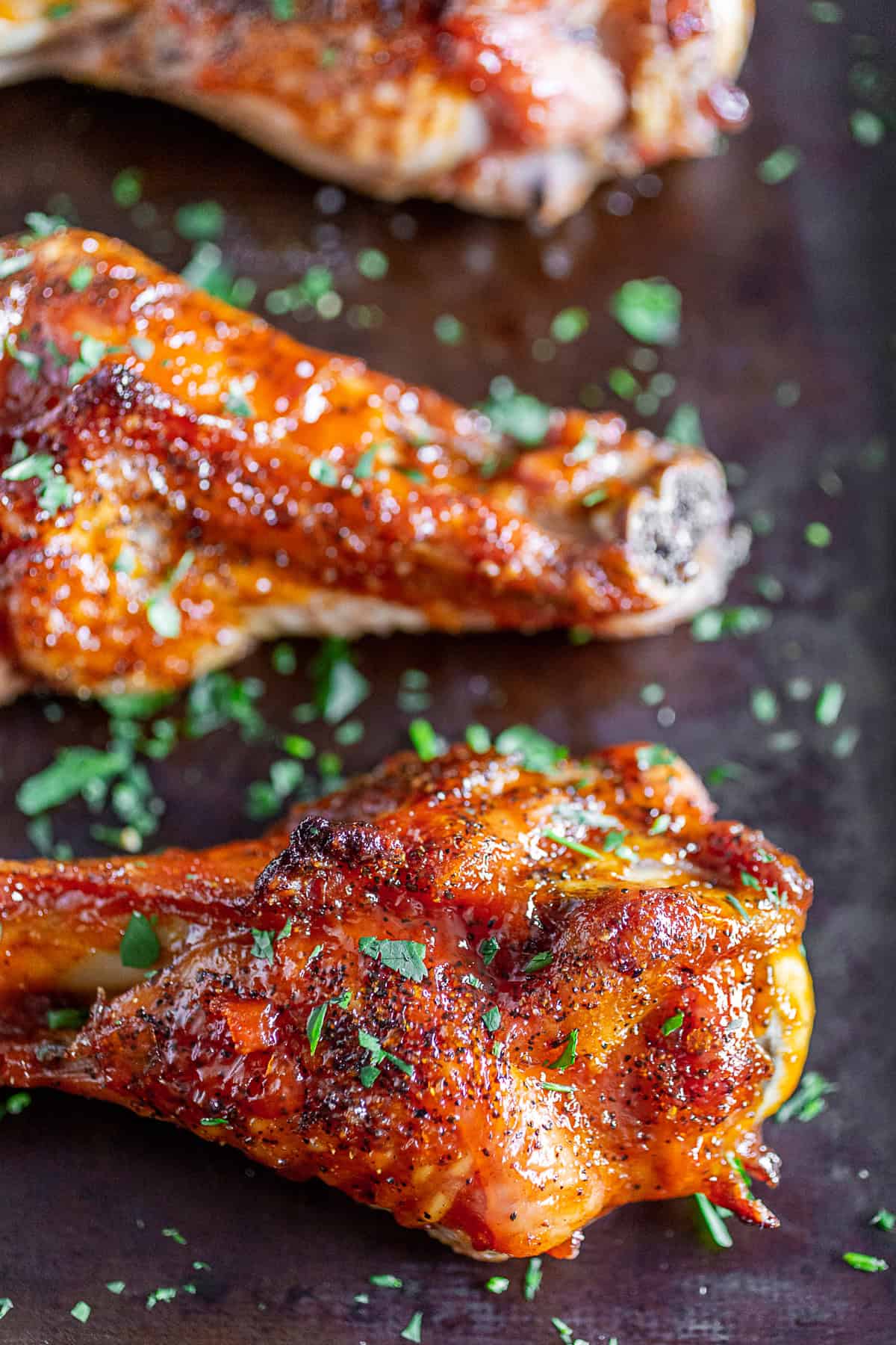 Peach BBQ Grilled Turkey Legs garnished with parsley.