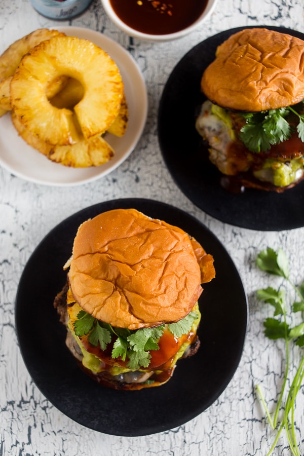 Two bbq pineapple burgers on a plate.