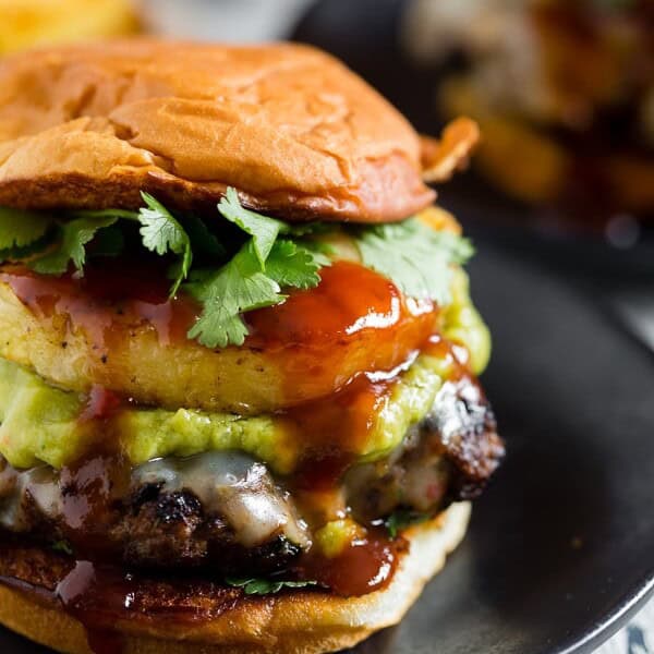 This bbq pineapple burger is the best thing to hit the burger scene. A perfectly seasoned beef patty mixed with cilantro, pineapple bbq sauce and topped with fresh grilled pineapple and smashed avocado!