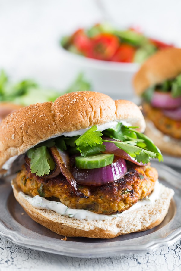 This chicken tandoori burger is packed full of spices and fresh chopped herbs. Piled high with fresh cilantro, cucumber, grilled onions and Greek yogurt sauce. This burger is perfect for all your summer BBQ parties!