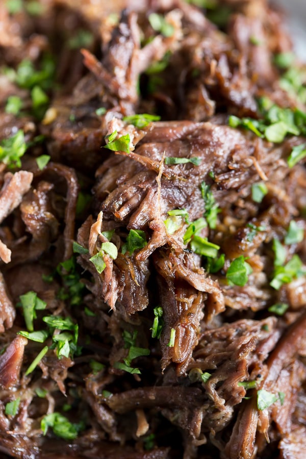 Homemade Mississippi Roast shredded on a white plate. 