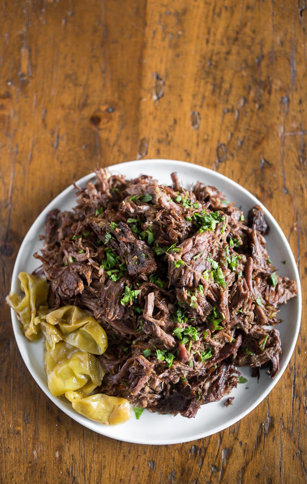 Homemade Mississippi Roast on a white plate with peppers. 