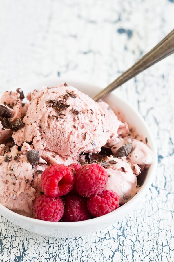 Raspberry Chocolate Chip Ice Cream in a bowl topped with chopped chocolate. 