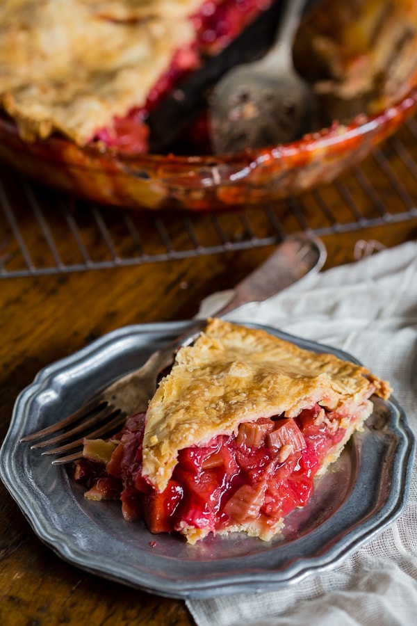 a slice of strawberry rhubarb pie on a plate.