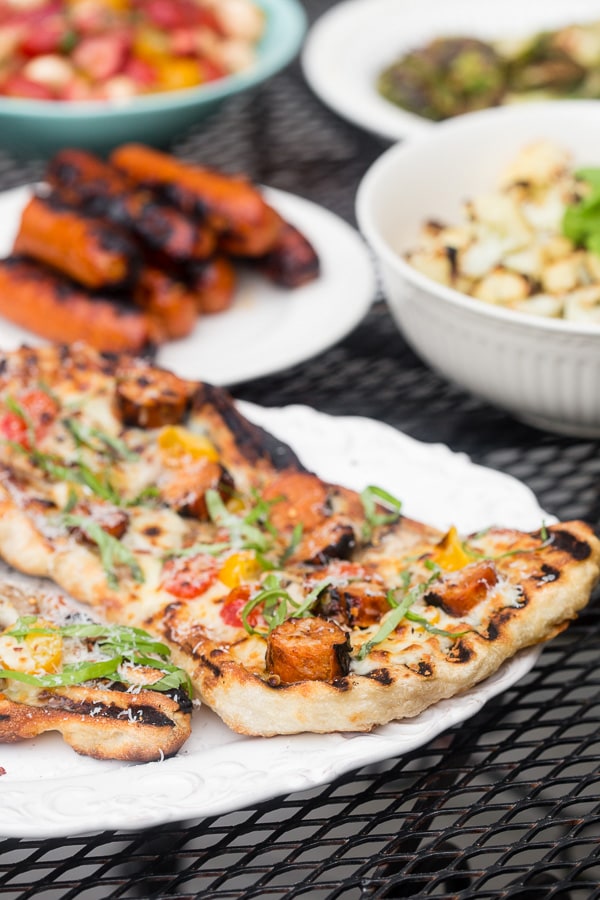 This grilled chicken sausage pizza is made 100% on the grill and is perfect for jazzing up your normal bbq routine. Topped with grilled chicken sausage, mushrooms, cherry tomatoes, mozzarella cheese and lots of fresh basil. You'll want to make this part of your summer as soon as possible!