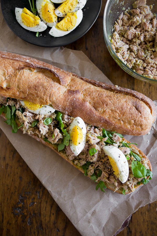 Pesto Tuna Baguette Sandwich sitting on parchment paper. 