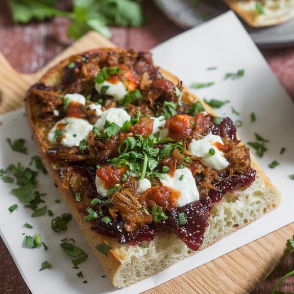 This fig and pig open-faced sandwich is the perfect way to bring flavor to your lunch or dinner. Crusty garlic bread topped with vanilla fig preserves, pulled pork, queso blanco cheese, chipotle salsa, cilantro and green onions.