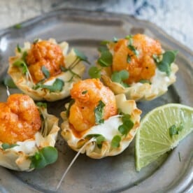These tequila lime shrimp phyllo cups are the perfect bite size appetizer. Slightly spicy but with a dollop of cooling lime sour cream sauce. You'll love this simple and easy appetizer!