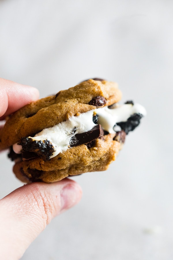 These peanut butter chocolate chip cookie s'mores take all the flavor of a childhood favorite and kick it up a few notches! What's not to love about toasted marshmallows and dark chocolate sandwiched in between peanut butter chocolate chip cookies?