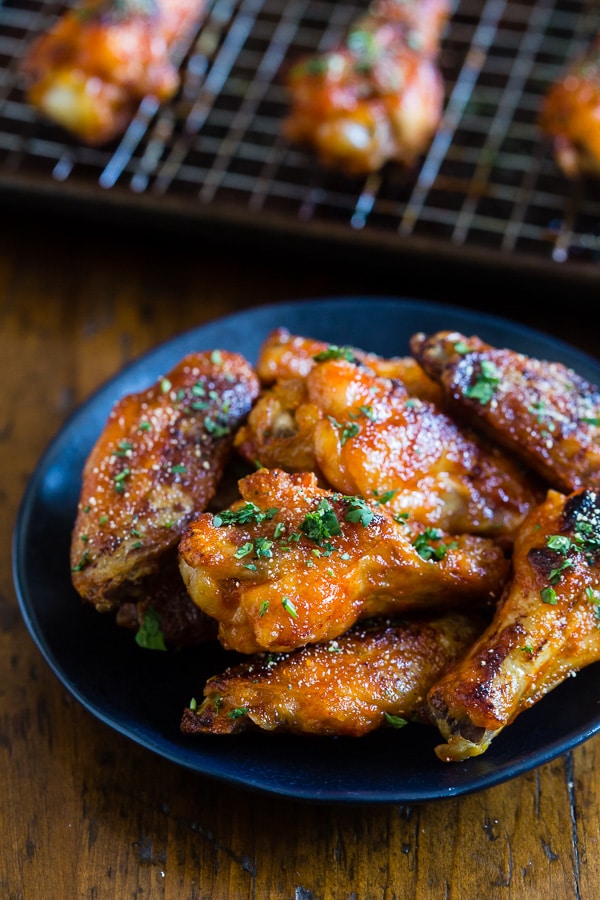 These sweet and spicy honey sriracha chicken wings are the perfect game day appetizer or weeknight dinner. Baked in the oven so they come out super crispy and glazed to perfection.