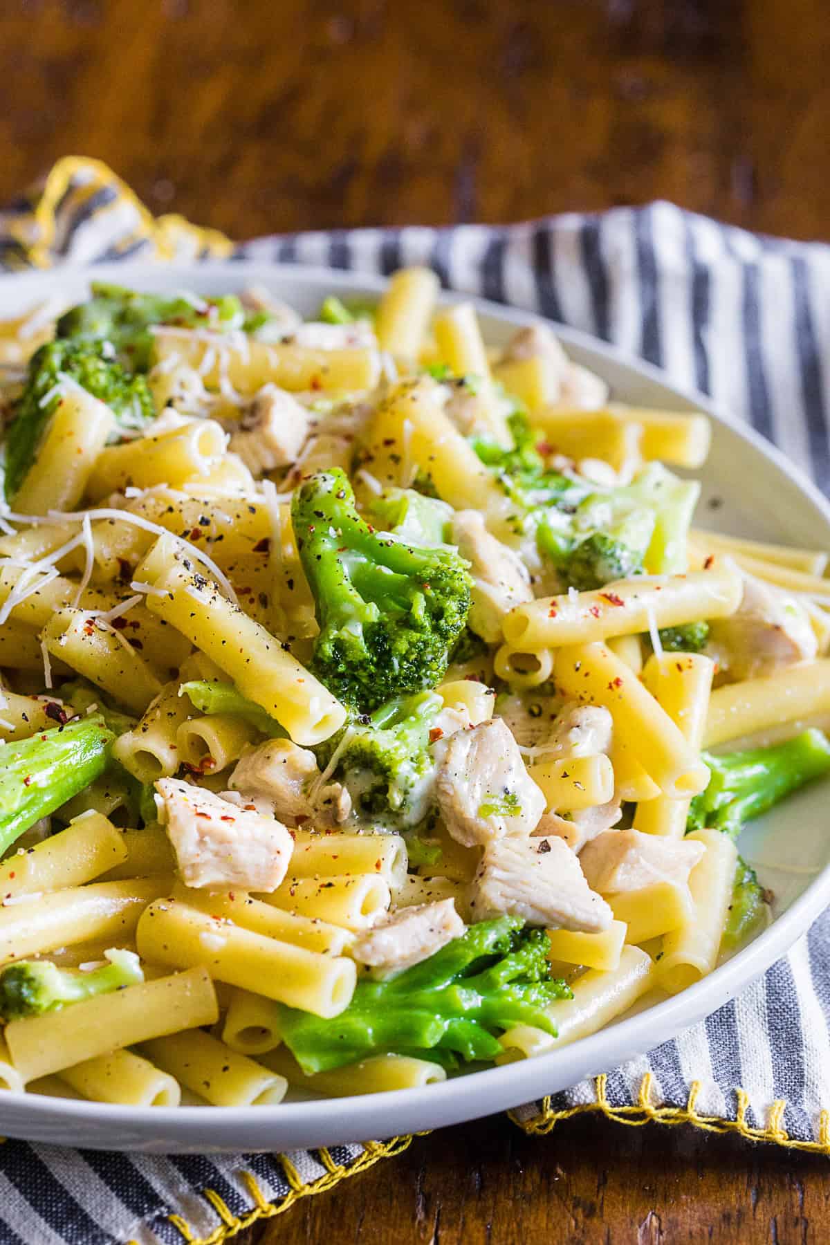chicken broccoli ziti pasta served with crushed red pepper.