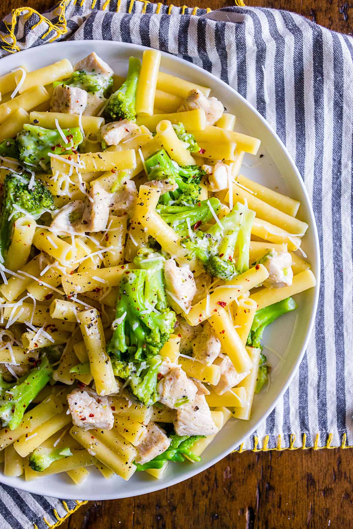 chicken broccoli ziti pasta on a white plate.