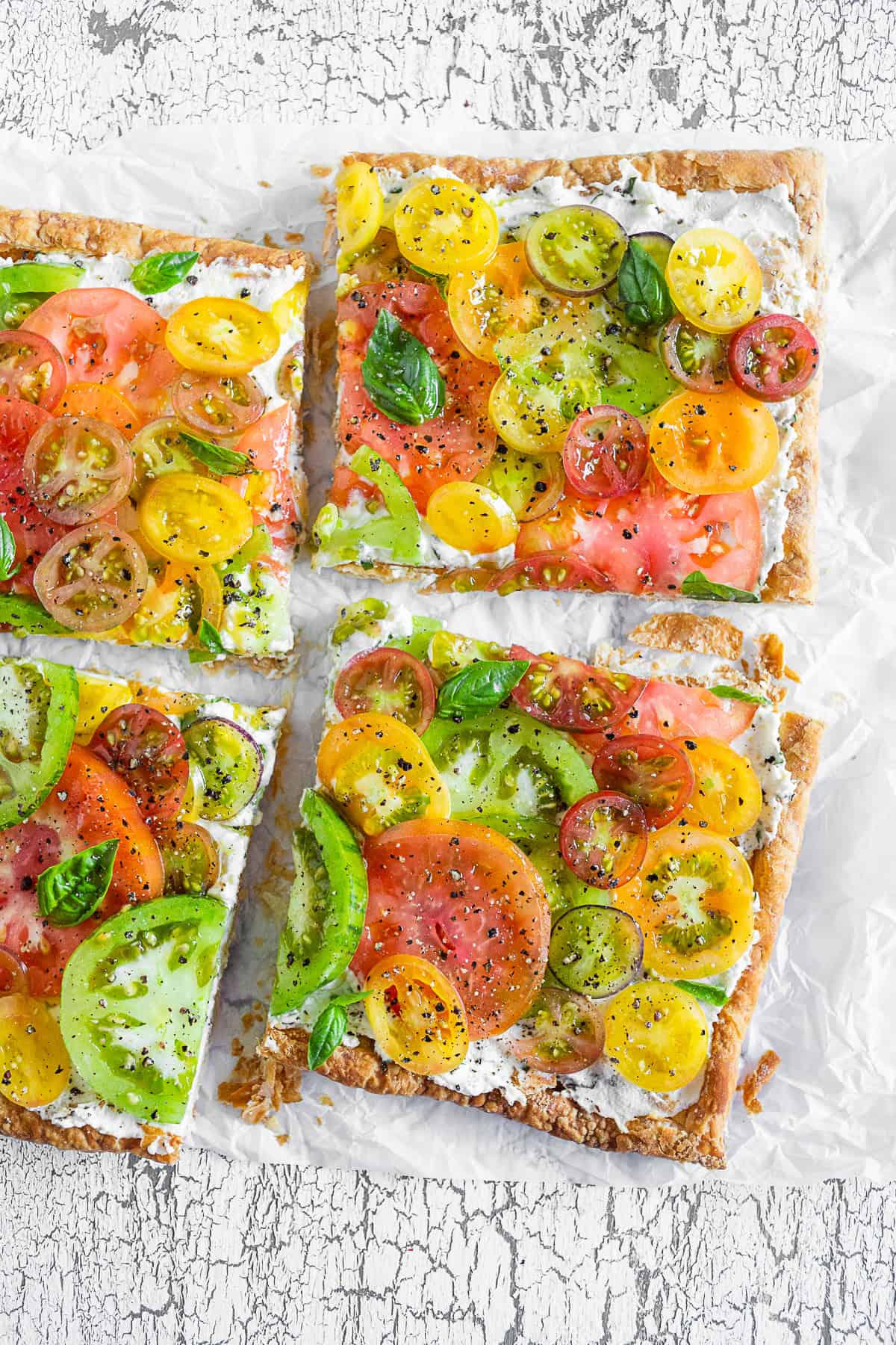 Sliced Heirloom Tomato Tart on parchment paper. 