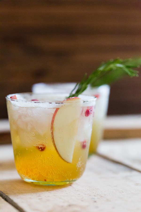 Apple Cider Pumpkin Beer Shandy in glasses with apples and pomegranate seeds. 