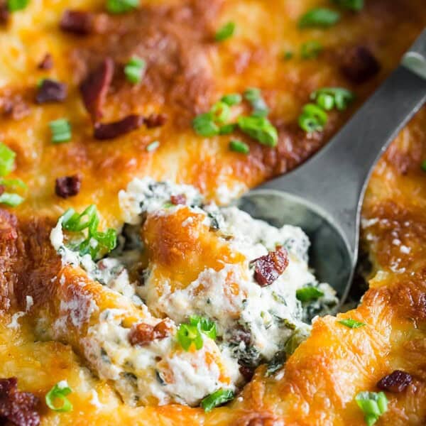 This baked spinach bacon dip is the perfect party snack. Packed full of spinach, crispy bacon, cream cheese, sharp cheddar cheese and green onions. This dip is so easy you'll want to make it every single weekend! PLUS it's ready in just 30 minutes!