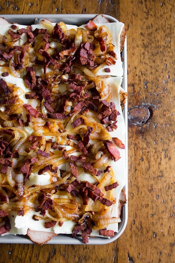 Bacon sprinkled on top of turkey, cheese, and onions.