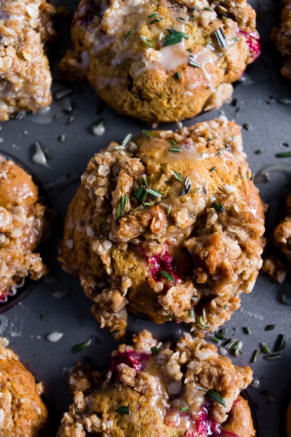 Cranberry Orange Rosemary Muffins topped with glaze in a muffin tin. 