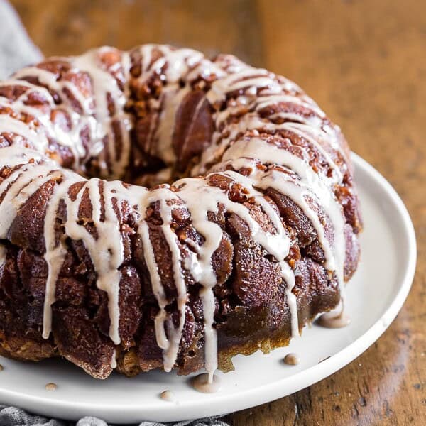Pumpkin spice apple monkey bread on a white plate with a grey napkin