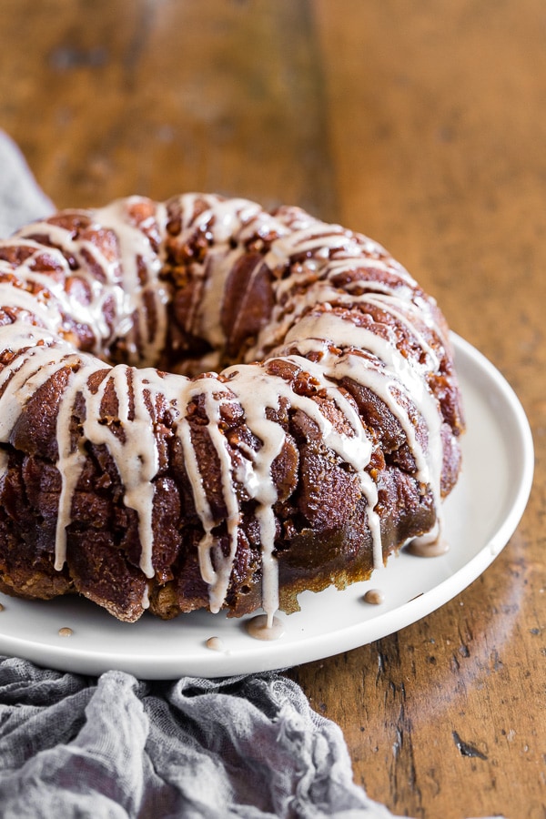 Pumpkin spice apple monkey bread on a white plate with a grey napkin