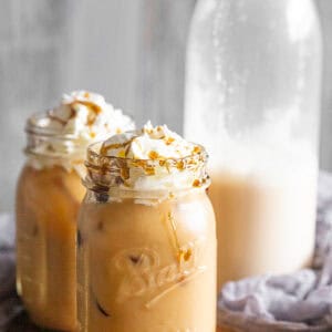 Horchata Coffee in 2 glasses with horchata in the background in a bottle.