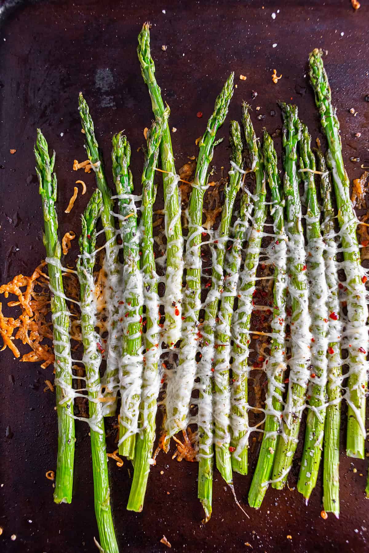 Parmesan Roasted Asparagus on a baking sheet pan with herbs. 
