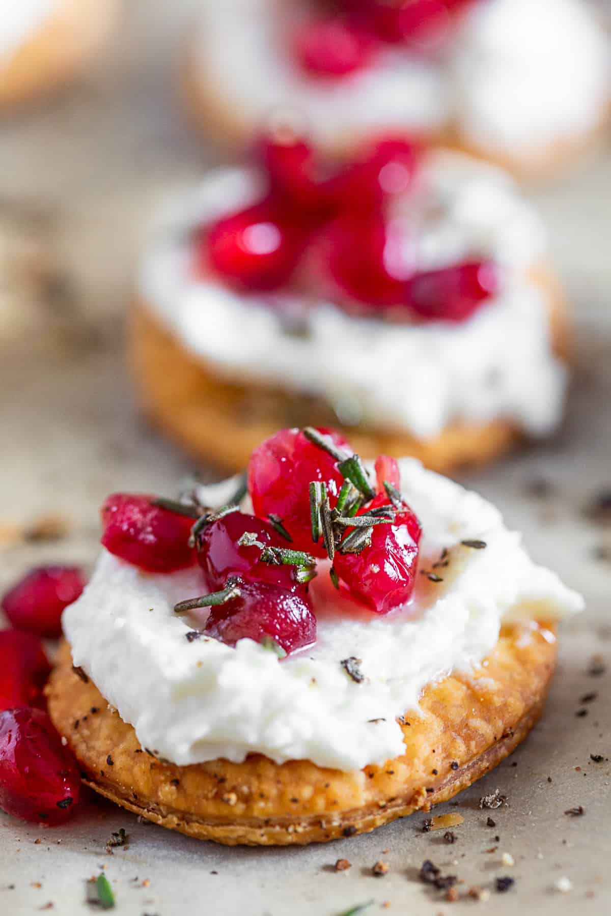 Whipped Goat Cheese Bites topped with pomegranate seeds and fresh rosemary. 