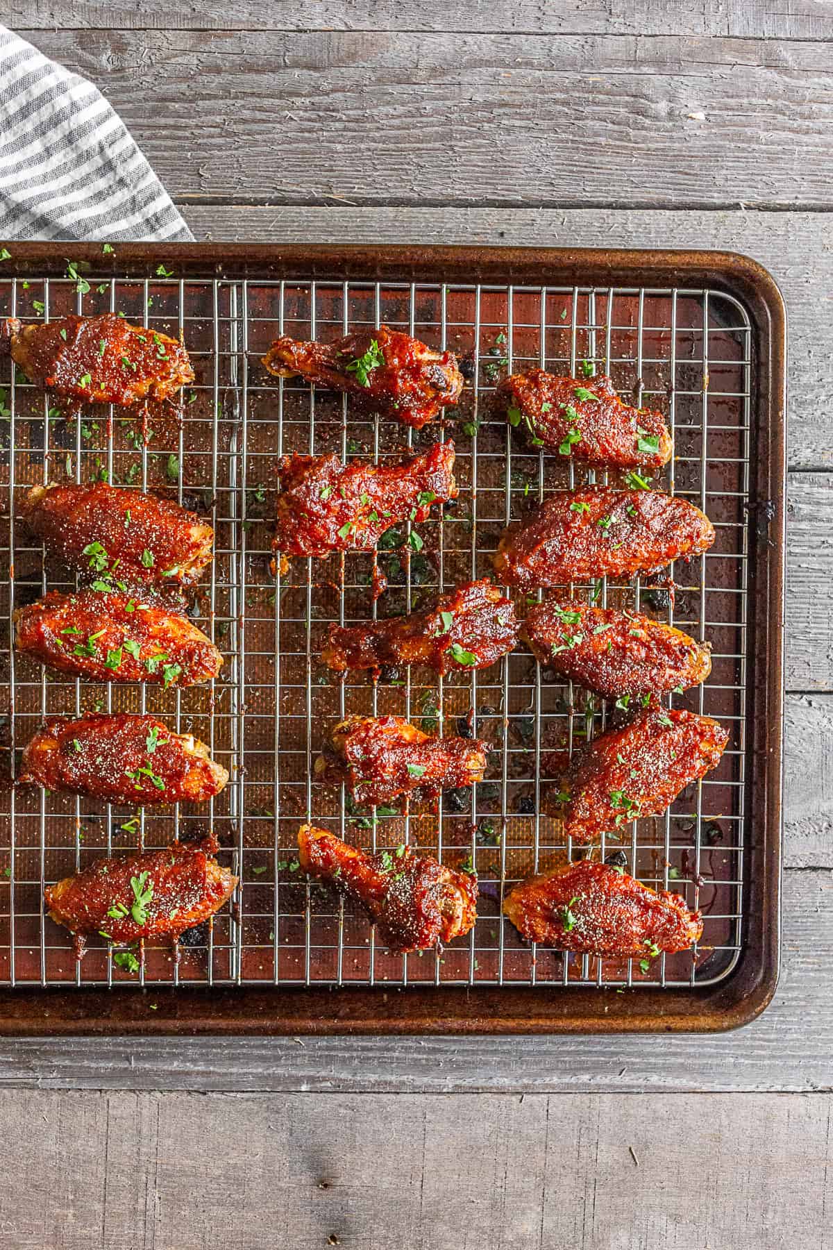 Baked apple butter chicken wings lined up on a grilling tray.