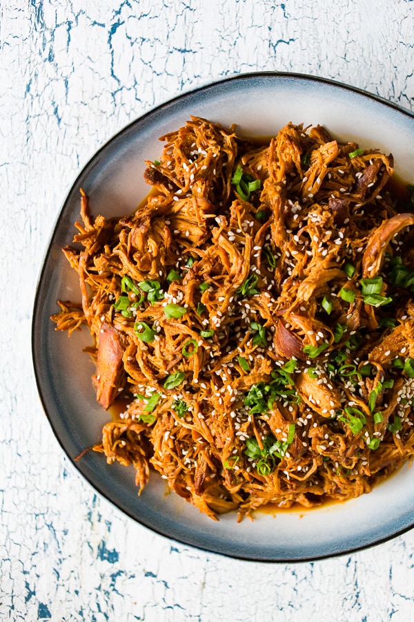 Slow Cooker Honey Sriracha Pulled Chicken garnished with sesame seeds. 